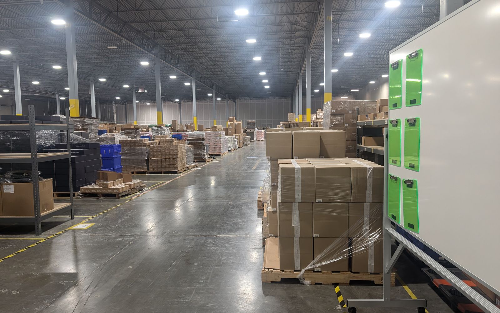 Warehouse aisle with racking and a pallet of cartons received at the dock