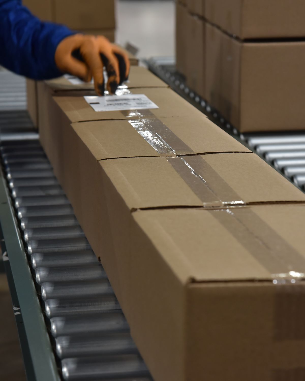 Team member applying a label to a sealed box on the conveyor